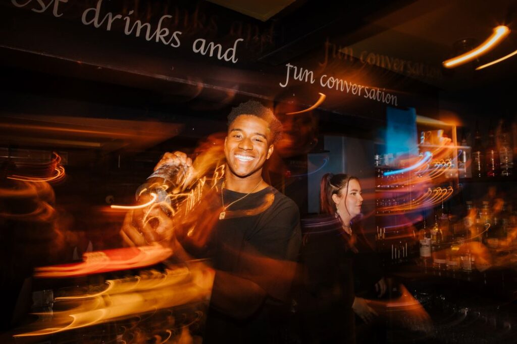 Bartender making cocktails with a smile on his face
