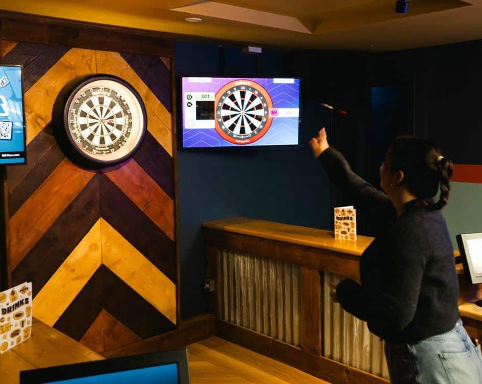 A person throwing a dart at an Interactive dart board at The Kelso venue in Loughborough