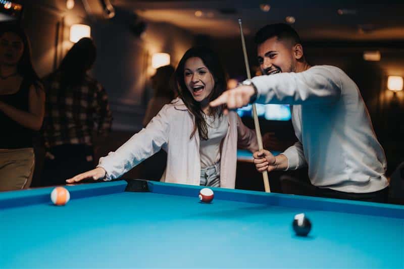 A couple on a date night playing pool